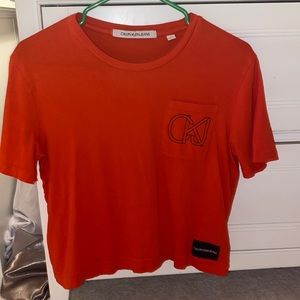Orange Calvin Klein shirt.
